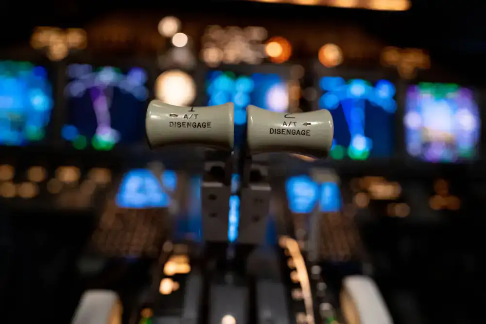 Wide view of an illuminated commercial flight simulator cockpit